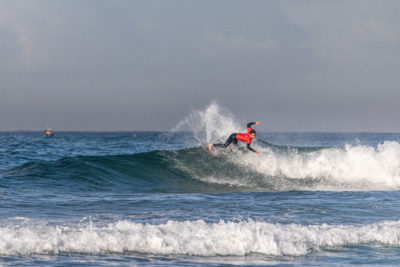 A surfer executing a beautiful maneuver at the QS surf competition in Anza, Morocco.