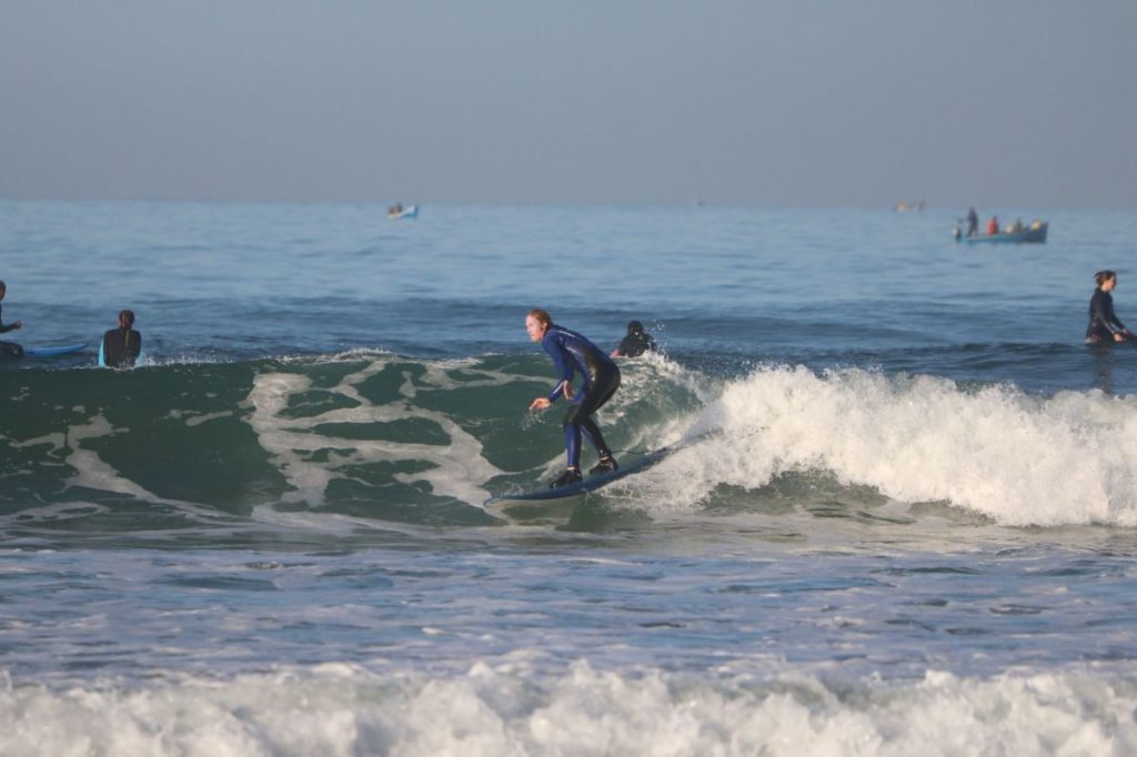 Photo of an advanced surfer expertly navigating a wave on their board in Taghazout, Morocco, with support from our surf school at Azul Guesthouse.