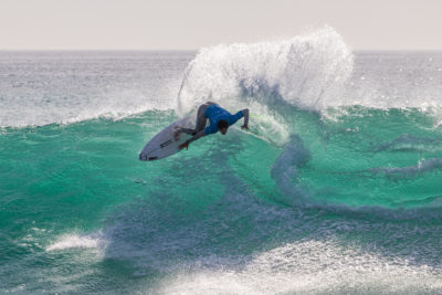 Ein Surfer führt während des WSL QS-Wettbewerbs eine atemberaubende Manöver aus.