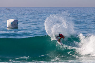 Ein Surfer, der während des WSL QS-Wettbewerbs eine beeindruckende Manöver ausführt.