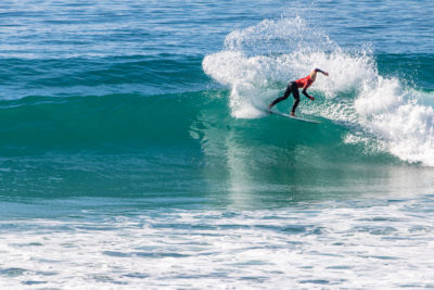 Ein Surfer, der während des WSL QS-Wettbewerbs eine beeindruckende Manöver ausführt.