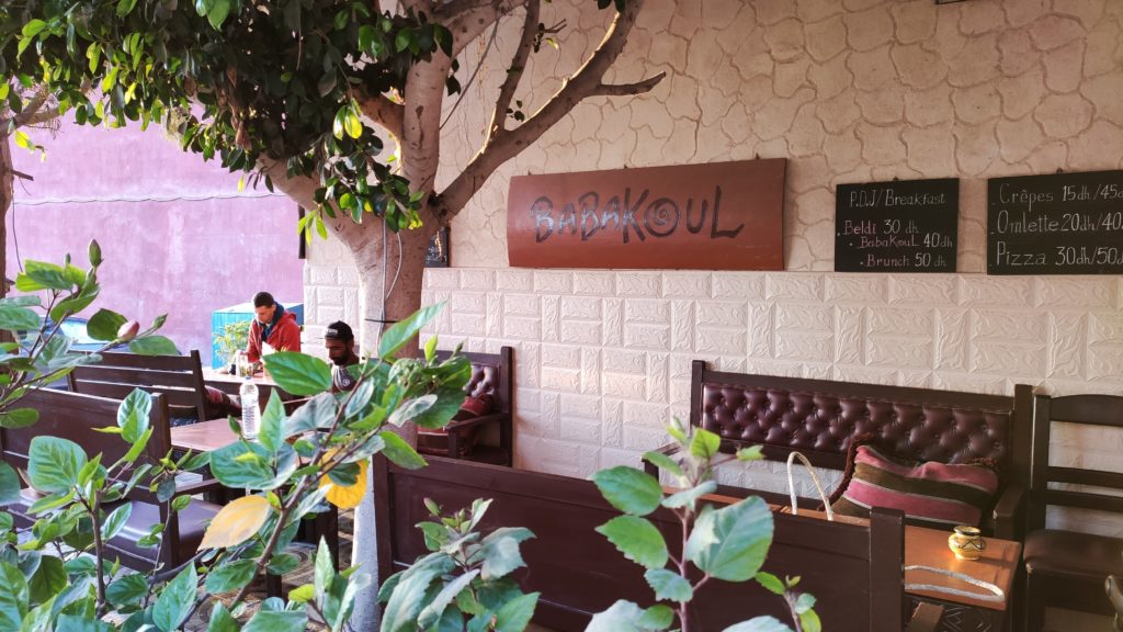 Babakoul Café in Tamraght, Morocco, with its charming outdoor seating area and vibrant atmosphere.