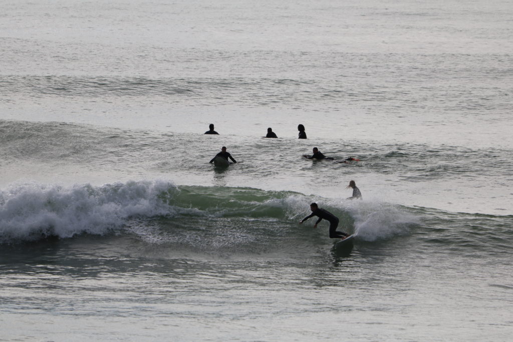 Photo of an experienced surfer skillfully riding a wave on their board in Taghazout, Morocco, with the expertise of our surf school at Azul Guesthouse.