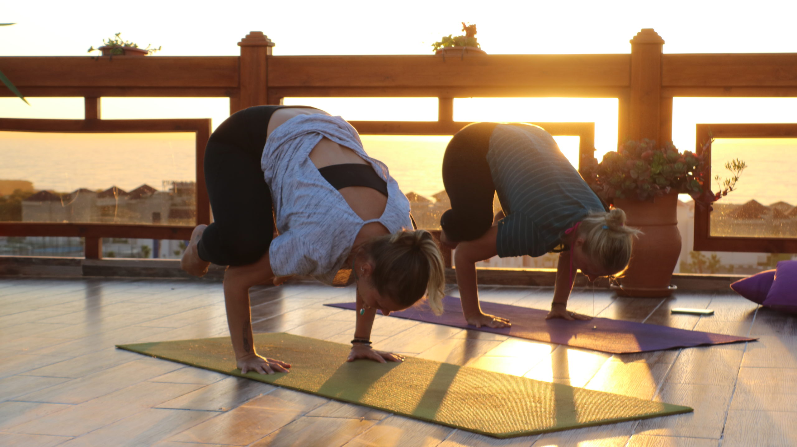 Two women practicing yoga on the terrace of Azul Guesthouse in Morocco, enjoying the sun and a relaxed atmosphere.