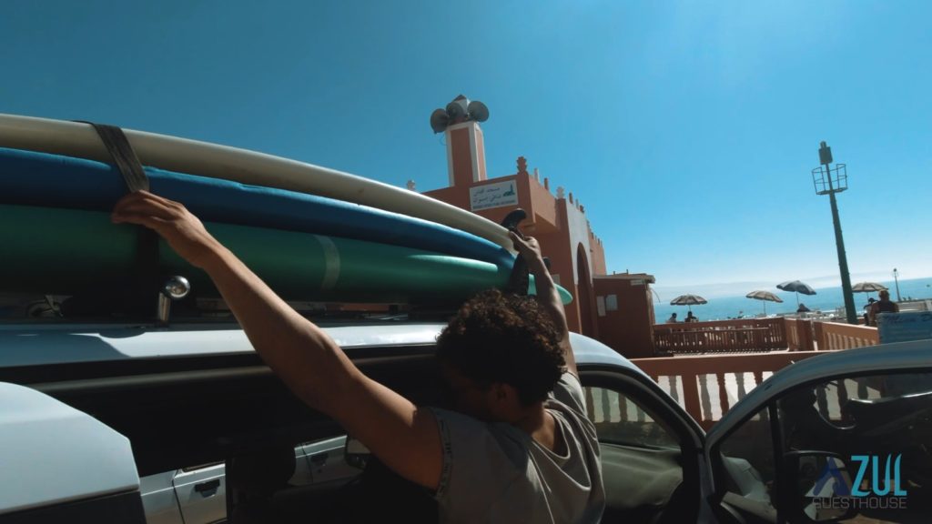 Cargando tablas de surf en el coche de Azul Guesthouse tras la sesión de surf en Imsouane, Marruecos