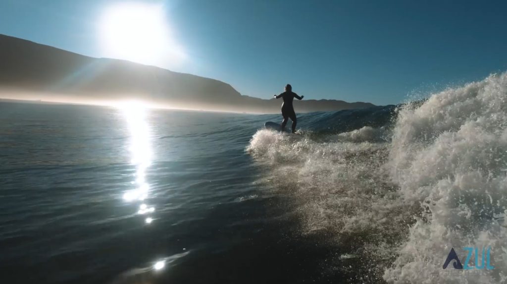 A girl catching a wave at the bay of Imsouane, Morocco, enjoying a perfect surfing session.