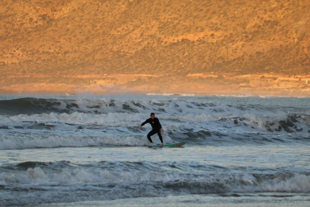 A beginner surfer standing up on a wave at Tafdna, Morocco, enjoying their first successful ride.






