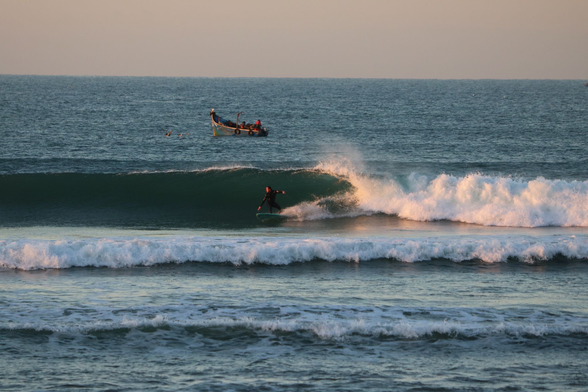 Un surfeur dans une belle vague à Desert Point à Taghazout au lever du soleil.
