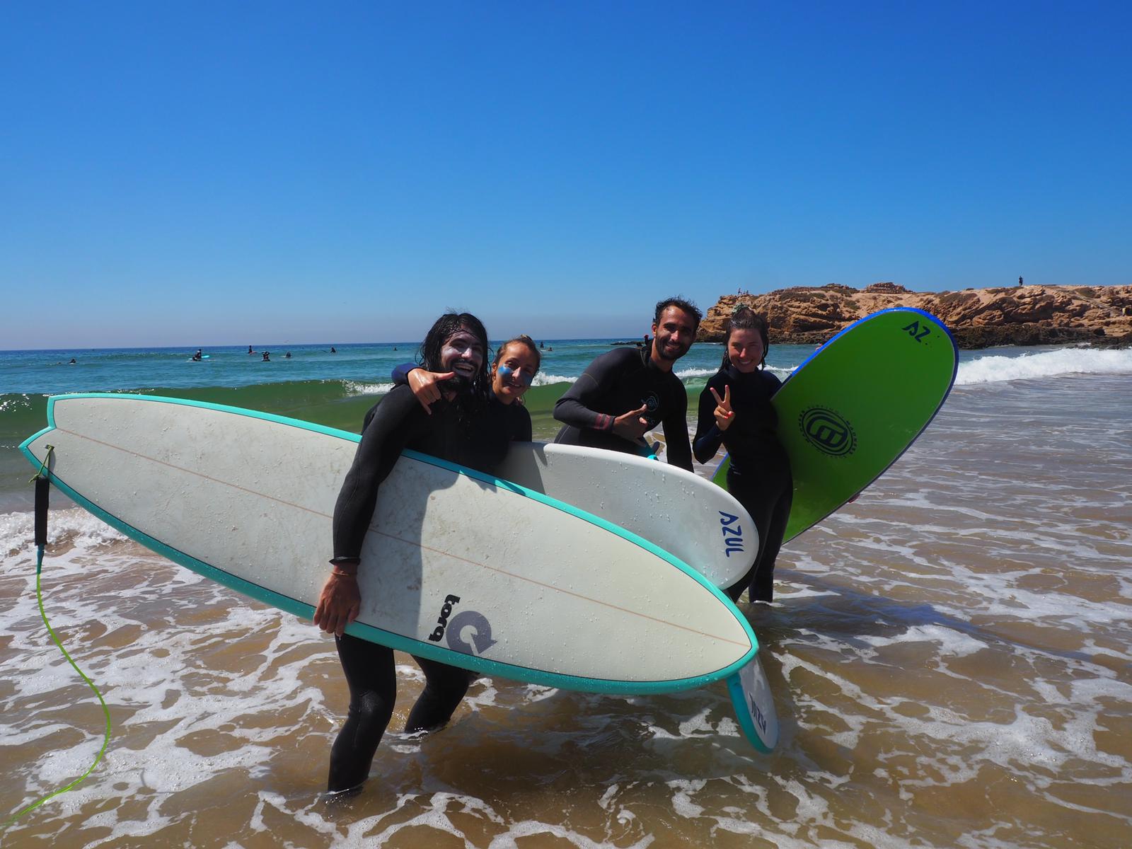 Surfeurs tenant leurs planches de surf sur la plage a Tamraght près de Taghazout au Maroc, après une épique session de surf
