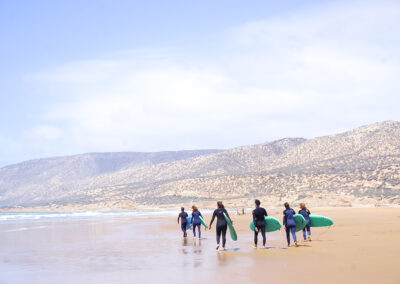 Surfistas Caminando Hacia el Agua en Desert Point – Azul Guesthouse Surf Camp en Marruecos
