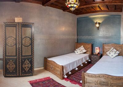 Chambre double standard confortable avec une ambiance chaleureuse, idéale pour un séjour surf et détente au Maroc.