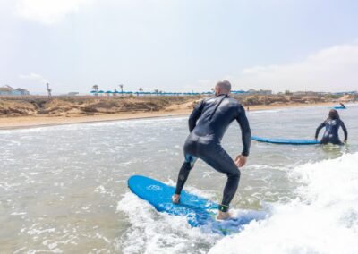 Surfista principiante poniéndose de pie por primera vez en la playa de Crocro, Marruecos