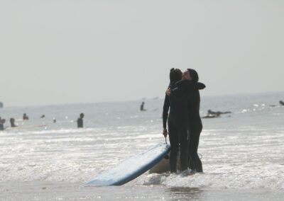 Una pareja se abraza tras lograr su primer take-off durante una clase de surf para principiantes en Marruecos