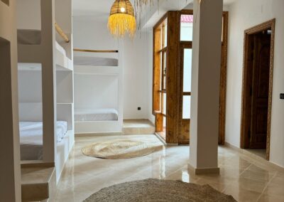 Dortoir pour hommes avec lits superposés et espace spacieux, idéal pour un séjour surf et yoga au Maroc