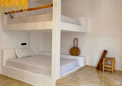 Dortoir pour hommes avec lits confortables, parfait pour un séjour surf et yoga au Maroc