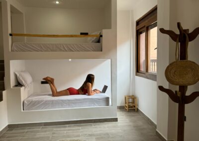 Dortoir pour filles avec lits confortables, idéal pour un séjour surf et yoga au Maroc