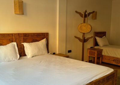 Lit double confortable dans la suite familiale d'Azul Guesthouse à Taghazout, idéal pour un séjour surf au Maroc.
